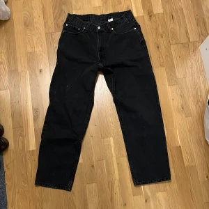 Vintage Levis 550 relaxad fit med vit färgstänk - Vintage svarta jeans från Levi's med klassisk femficksdesign och knappgylf. är tillverkade i slitstarkt denim med baggy skater fit