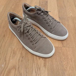 Beiga sneakers i mocka från Suitsupply i stl 42 - Snygga bruna/beige sneakers i mocka med snörning och vit sula. Från Suitsupply i stl 42. Sparsamt använda.