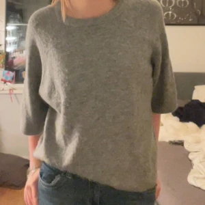 Grå tröja från 157 -  Jag säljer den trändigs Mysiga gråa tröjan från 157 med trekvartsärm. Perfekt för kyligare dagar och enkel att matcha med jeans eller kjol. Tröjan har en klassisk design med rund hals och är tillverkad i ett mjukt material.