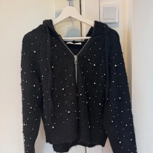 Kofta med pärlor  - Snygg svart hoodie från ZARA med dragkedja och pärldetaljer över hela tröjan. Knappt använd. Storlek M men sitter som en S❤️