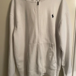 Vit hoodie från Polo Ralph Lauren - Säljer en vit hoodie från Ralph Lauren då den inte passade mig. Den har en liten slitning så du kan se på den sista bilden men den syns inte när du väll har på tröjan men annars är den bra