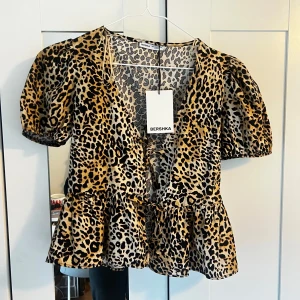 Leopardmönstrad blus från Bershka - Trendig leopardmönstrad blus med knutdetaljer  från Bershka med puffiga korta ärmar och volangdetalj i nederkant💕