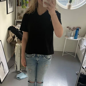 Svart t-shirt med spetsdetaljer - Snygg svart t-shirt med korta ärmar och spetsdetaljer på baksidan. Perfekt för en stilren look med en twist. Storlek S💗