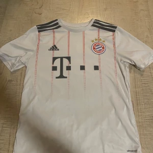 Vit Bayern München fotbollströja - Säljer en vit Bayern München fotbollströja från Adidas med korta ärmar. Lewandowski och nummer 9 är tryckt på ryggen. 