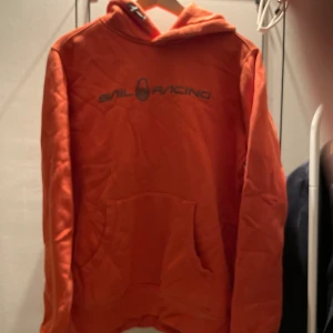 Orange hoodie från Sail Racing - Säljer en orange hoodie från Sail Racing! Knappt använd. Nypris 1299kr. Den är lite nopprig men inget man tänker på