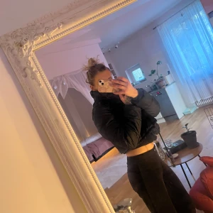 Svart pufferjacka - Snygg svart pufferjacka med dragkedja och hög krage. Perfekt för kyligare dagar och ger en trendig look. Jackan är croppad och har en normal passform. Passar xs/S