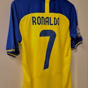 Ronaldo tröja Al nassr 22/23 helt ny - Säljer nu den helt nya Ronaldo tröjan från Dune(klädesmärket). Tröjan är från säsong 22/23 och storleken är L men passar även M.