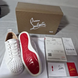 Vita sneakers från Christian Louboutin - Snygga vita sneakers från Christian Louboutin med den ikoniska röda sulan. Skorna har snörning och är dekorerade med vita nitar på tån för en edgy look. Perfekta för att ge din outfit en lyxig touch. Säljes pga fick dessa i julklapp och dem var för små. Stl 41 2499 kr. Priset är absolut inte hugget I sten, Tveka inte att fråga vid minsta lilla fråga. Byten är också aktuellt. Använda 1 gång så intensivt ny skick