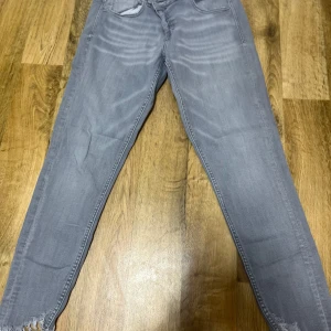 Grå jeansbyxor - Snygga grå jeansbyxor med en tight passform. De har en klassisk design med fem fickor och en dragkedja. Perfekta för en stilren look. Priset går att diskuteras 