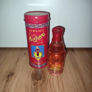 Versace Red Jeans Woman Eau de Toilette - Versace Red Jeans Woman Eau de Toilette i en elegant röd flaska med matchande röd metallförpackning. Doften är fruktig och blommig, perfekt för den som vill ha en livlig och ungdomlig parfym. Flaskan har en unik design med Versace-logotypen ingraverad.