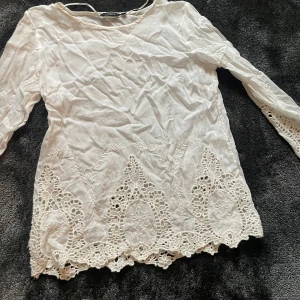 Vit blus från Lindex - Säljer en vacker vit blus från Lindex med spetsdetaljer längs nederkanten. Blusen har trekvartsärmar och en rund halsringning. Perfekt för en elegant look.❤️💕❤️skriv får fler bilder 