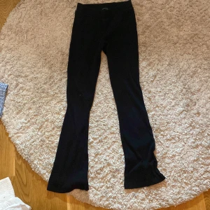 Svarta ribbade byxor från Ullared - Snygga svarta ribbade byxor från XOXO (ullared) med hög midja och bootcut-stil. Perfekta för en trendig look med en bekväm passform. Byxorna är tillverkade i ett stretchigt material som ger en skön känsla hela dagen.