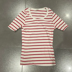 Vit och röd randig t-shirt  - Snygg vit t-shirt med röda ränder. Den har en rund halsringning och korta ärmar. Skriv för mer bilder eller andra frågor :) 