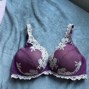 Lila spets-bh från Intimissimi - Säljer en vacker lila bh från Intimissimi med vita spetsdetaljer. Bh:n har justerbara axelband och hakknäppning bak. Perfekt för att känna sig extra fin.