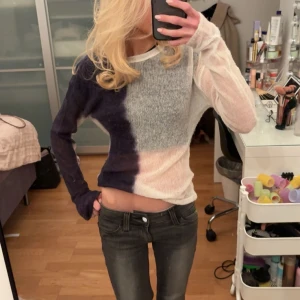 Flerfärgad stickad tröja - Säljer en unik flerfärgad stickad tröja med blockmönster i blått, grått och vitt. Från Weekday och är i nyskick 