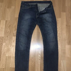 Mörkblå jeansbyxor - Snygga mörkblå jeans från polo Ralph Lauren med klassisk pass form. Jeansen är i stolek 33-34. Slitningarna längst ska vara där 