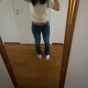 Blå jeansbyxor - Säljer ett par klassiska blå jeansbyxor med låg midja och en straight passform. Perfekta för en avslappnad stil. De har en enkel design med knappar och dragkedja framtill. W28 L32