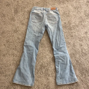 Ljusblå bootcut jeans från Gina Tricot - Säljer ett par ljusblå bootcut jeans från Gina Tricot. De har en klassisk femficksdesign och är perfekta för en avslappnad stil. Passar bra till både sneakers och klackar.
