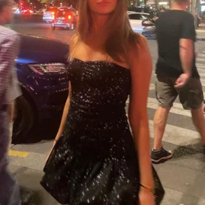 Svart klänning - Snygg svart axelbandslös klänning med glittrigt material och volangdetaljer. Perfekt till nyår!!😍😍😍 stretchiga material och har tejp liknande material så den sitter fast vid bröstan,  så passar xxs-s skulle jag säga!! Det är den äkta från meet me there 