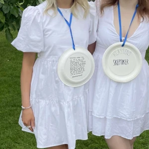 Vit klänning med puffärmar -  Studentklänning med puffärmar och en öppen rygg. 