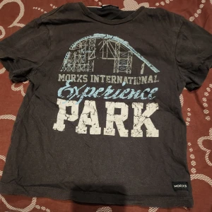 Svart t-shirt med tryck från Morys - Cool svart t-shirt från Morys med ett stort tryck på framsidan som säger 'Morys International Experience Park'. Perfekt för en avslappnad stil.