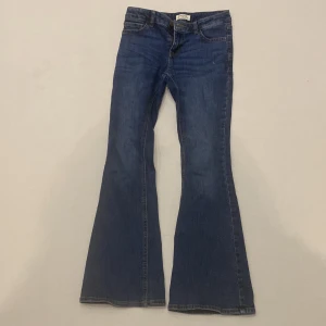 Blå bootcut jeans från Lindex - Snygga blå bootcut jeans från Lindex i storlek 152. Perfekta för en avslappnad stil med en klassisk femficksdesign och bekväm passform. Tillverkade i ett slitstarkt denimtyg.