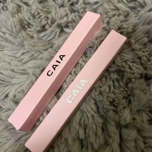 Ögonskugspenna silver guld  CAIA - Säljer flera sminkprodukter från CAIA. Inkluderar förpackningar i rosa och silver med texten 'CAIA'. Perfekt för den som älskar stilren design och högkvalitativa produkter. Helt oanvänd. Färger snow spice och ice campange limiterad