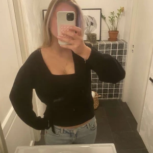 Svart omlottkofta  - Snygg svart omlottkofta med långa ärmar och knytning i midjan. Den är lite nopprig men det syns inte