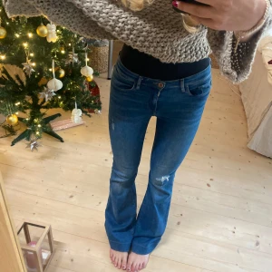 Blå lågmidjade bootcut jeans - Snygga blå bootcut jeans med slitna detaljer. SÅ snygga! Linnerbenslängd: 80, midjemått 38 (stretchinga)❤️❤️