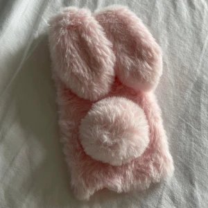 Rosa fluffigt mobilskal för iPhone 6 Plus - Säljer ett supersött rosa mobilskal med kaninöron och en fluffig svans. Skalet är designat för iPhone 6 Plus och ger en unik och lekfull look. Perfekt för dig som vill ha något annorlunda och mysigt till din mobil!