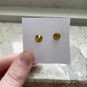 Guldörhängen i minimalistisk design - Snygga och stilrena guldörhängen med en enkel, rund form. Perfekta för att ge en elegant touch till din outfit. Dessa örhängen är lätta och bekväma att bära hela dagen. Tyvärr saknas ploppen som håller öronhänget på plats!