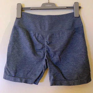 Blå shorts från Astani Wear - Säljer ett par bekväma blå shorts från Astani Wear. De är tillverkade i en mjuk och stretchig blandning av nylon och spandex, perfekt för träning. Shortsen har en elastisk midja för extra komfort & en scrunch som framhäver rumpan. Storlek L, passar M-L. Använda fåtal gånger & i superbra skick.