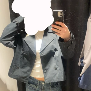 Svart kappa med knappar - Snygg svart trenchkappa med dubbelknäppning. Perfekt för en stilren look. Kappan har långa ärmar och en croppad passform som ger en modern touch. Nypris var 30€ Har endast provat jackan och lappen finns kvar ännu. Jackan från lager157 och är i storlek S💓