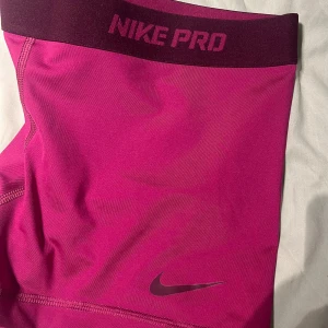 Rosa träningsshorts från Nike Pro - Snygga och bekväma rosa träningsshorts från Nike Pro. Perfekta för intensiva träningspass med en tight passform och elastisk midja för extra komfort.