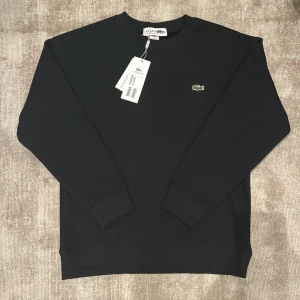 Svart tröja från Lacoste - Svart Lacoste tröja till salu. För liten på mig, säljer därmed. Perfekt julklapp inför vintern. Simpel och fin. Kan gå ned i pris vis snabb affär. 