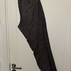 Grå byxor från Four Ten  - Snygga italienska byxor i grått med en mörk ton. De har en rak passform och en lägre midja. Byxorna har en knappstängning och en dragkedja. De har även två fickor framtill och två fickor baktill.  Storlek: 32 midja osäker på exakt längd men cirka 30/31.   Nypris: ~1400kr   Använd cirka 3 gånger