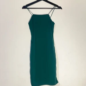 Esmeraldgrön axelbandslös mini klänning - Elegant esmeraldgrön minidress med smala axelband och en figurnära passform. Perfekt för en stilren look eller nu till julen !