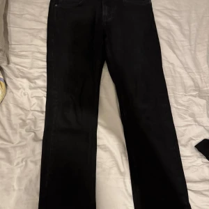 Svarta jeansbyxor - Snygga svarta jeansbyxor med klassisk design. De har en rak passform och är perfekta för en stilren look. Byxorna har fem fickor och en knappgylf. Pris kan diskuteras!