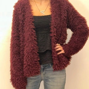 Vinröd teddyjacka - Mysig vinröd teddyjacka med långärmad design. Perfekt för att hålla sig varm och stilren under kyliga dagar. Jackan har en fluffig textur som ger en trendig look.