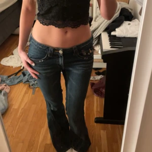 Lågmidjade bootcut jeans från true religion - As snygga lågmidjade bootcut jeans från true religion. Knappt använda, och är därför i jättebra skick. Dem saknar bara enstaka diamanter på ena fickan. Se bild. Köpta i en butik i Köpenhamn, dem är sydda bootcut men det syns knappt. Storlek 28, men skulle uppskatta dem till stor S/M. Jag är 169 och dem passar bra i längden. Innerbenslängden är 78 cm och midjemåttet är 40 cm. Grenhöjden är 19 cm. ❤️