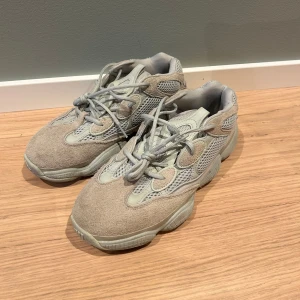 Yeezy 500  - Snygga grå sneakers med en chunky sula och detaljer i mocka och mesh. Perfekta för en casual look med bra komfort och stil. Bra skick använda fåtal gånger, köpta på sneakershyllan
