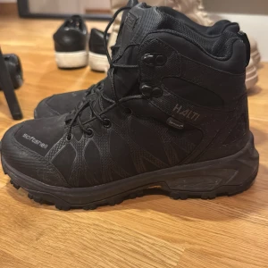 Svarta kängor från Sortsnell - Stabila och robusta svarta kängor från Sortsnell med snörning. Perfekta för utomhusaktiviteter med slitstark sula och hög ankelstöd.