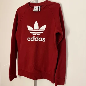 Adidas sweatshirt röd herr - Mörk röd sweatshirt från Adidas i herrstorlek. Bara använd få gånger och är i fint skick!