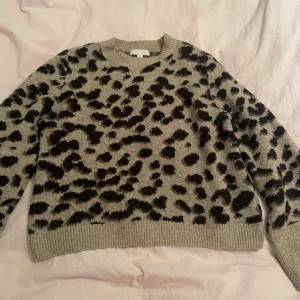 Beige leopardmönstrad tröja från H&M - Säljer en snygg beige tröja från H&M med leopardmönster i svart. Tröjan har långa ärmar och en rund halsringning 🐆