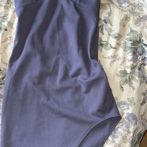 Mörkblå klänning med smala axelband - Elegant mörkblå klänning med smala axelband,  Klänningen har en asymmetrisk nederdel, aldrig använt