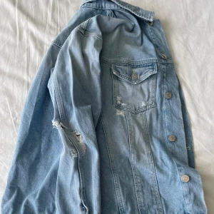 Ljusblå jeansjacka från Jack & Jones - Säljer en snygg ljusblå jeansjacka från Jack & Jones. Den har en cool, sliten look med revor på ärmarna och bröstfickan. Passar till det mesta, och mycket premium. Frågor? Skriv!