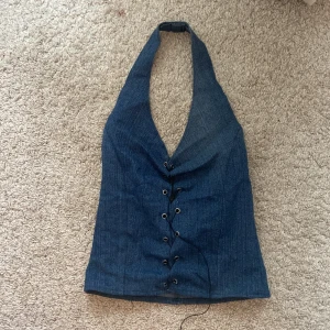 Halterneck topp - En ascool halterneck topp i jeansmaterial med snörning! Använd endast en gång så väldigt bra skick! Köpte på plick för några år sedan så den är hemmagjord!