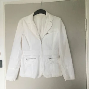Vit Kappa Vintage - Vit Kappa som är Vintage. Köpt länge sen och står inget märke på. Har tre fickor med dragkedjor. Är i bra skick och har lite lätt gula toner på vissa ställen. Skriv för bild, annars inga skador. Skriv vid funderingar✨