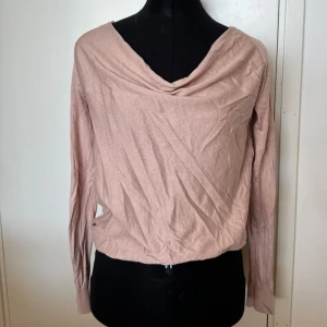 Rosa långärmad topp - Säljer en superfin rosa långärmad topp med en draperad halsringning i bomull och Mulberry silke. Perfekt för både vardag och fest! Den är i ett mjukt och bekvämt material som känns skönt mot huden. Passar perfekt till jeans eller kjol för en chic look.