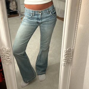 Lågmidjade jeans  - As snygga lågmidjade ljusblå jeans!!!!  Måttet rakt över midjan är 37 cm och innebenslängden 77 cm  Små slitningar längst ner
